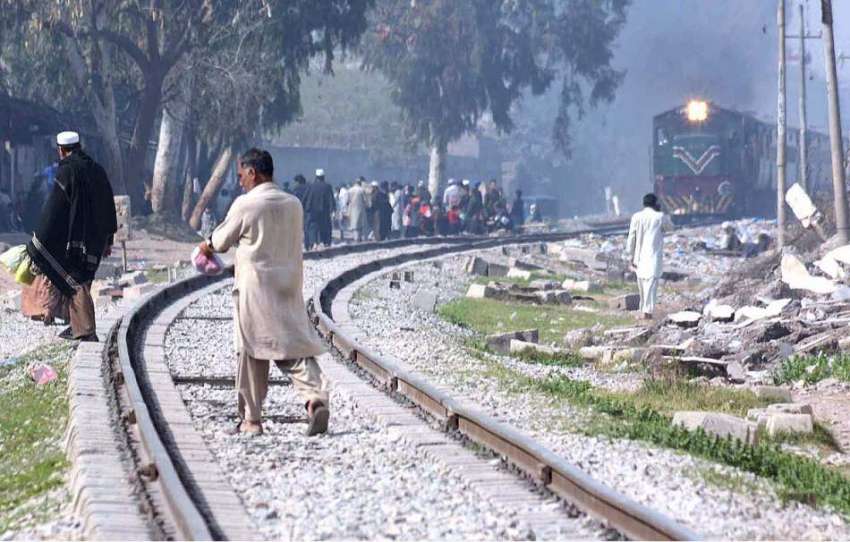 پشاور: ریلوے ٹریک کو بے خبری سے عبور کرنے والے افراد جو کسی ..