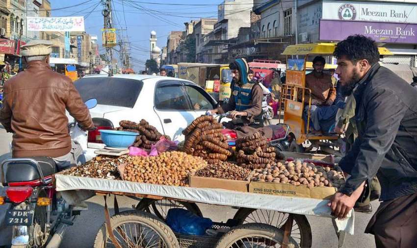 سرگودھا: اردو بازار میں خشک میوہ فروخت کرتے ہوئے ایک دکاندار ..
