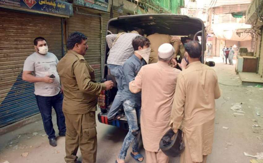 لاہور: پولیس اہلکار لاک ڈاؤن کی خلاف ورزی پر ہال روڈ پر دکانیں ..