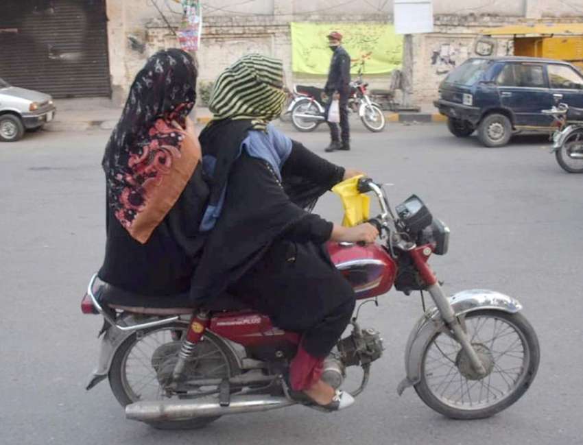 لاہور : دوخواتین موٹرسائیکل پر بیٹھے شملہ پہاڑی چوک سے گزررہی ..