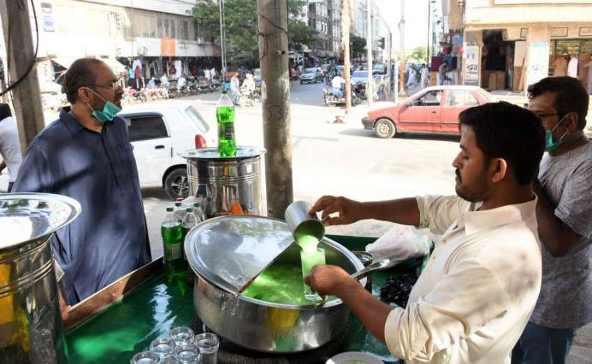 کراچی میں جاری شدید گرمی میں ایک ریڑھی والا ٹھنڈا مشروب ..