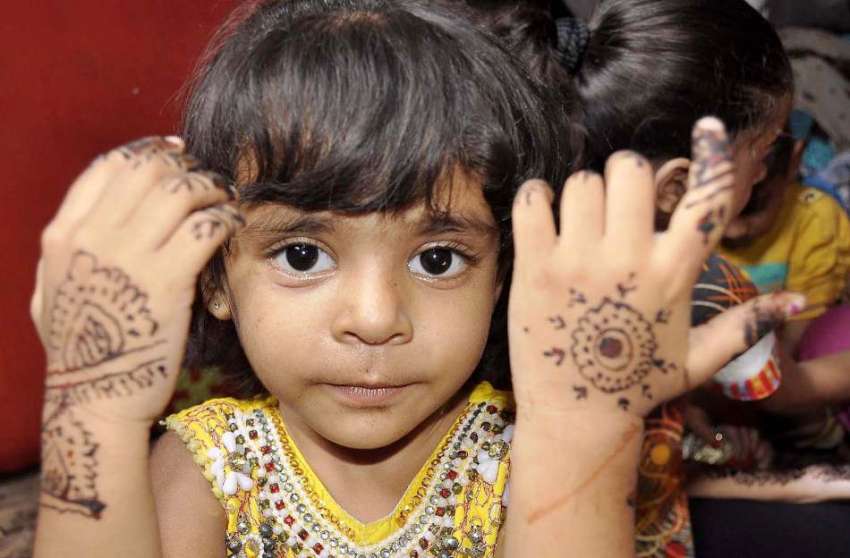 کراچی :عید کی تیاریوں میں مصروف ایک بچی مہندی لگانے کے بعد ..