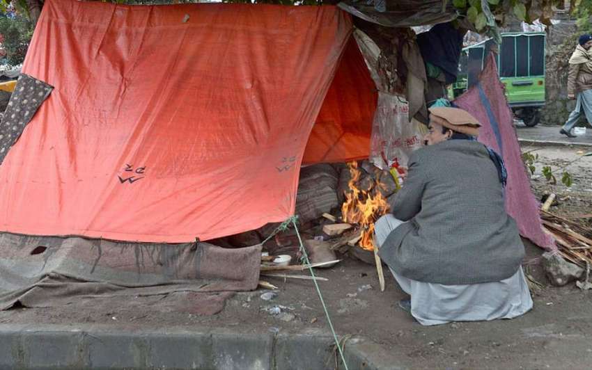 راولپنڈی: شہر میں ٹھنڈے موسم کے دوران ایک شخص ڈبل روڈ پر ..