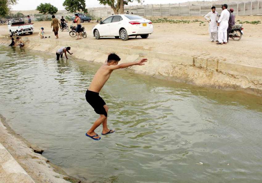 کراچی: گرمی کی شدت کے باعث بچے منگھو پیر کے علاقے سے گزرنے ..
