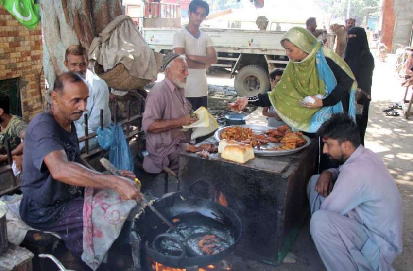کراچی:شہری ایک سٹال سے پکوڑے خرید رہے ہیں۔