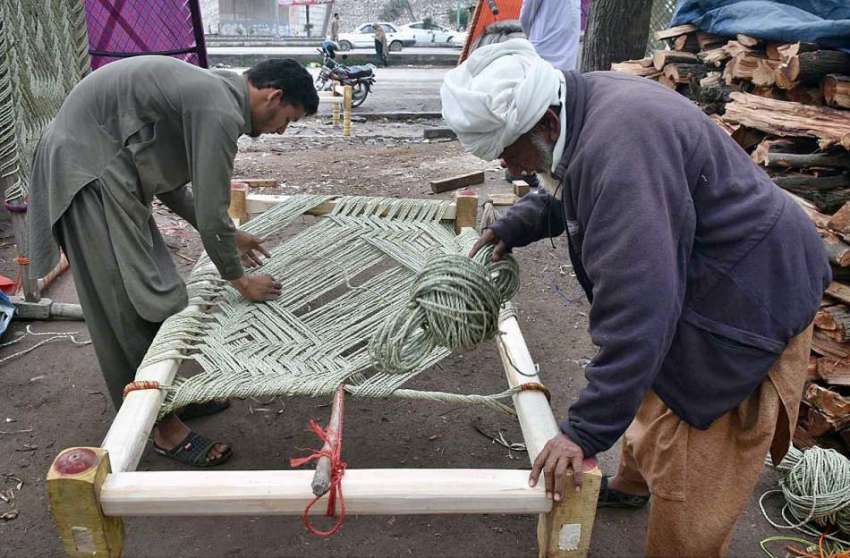 پشاور: مزدور روایتی چارپائی باندھنے میں مصروف ہیں۔
