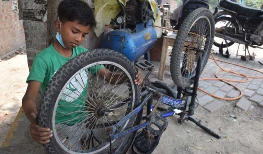 لاہور، ایک محنت کش بچہ سائیکل مرمت کر رہا ہے۔