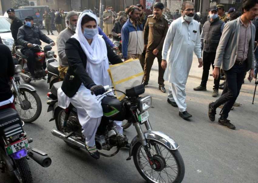 لاہور، ایک موٹرسائیکل سوار خاتون اپنی منزل کی جانب گامزن ..