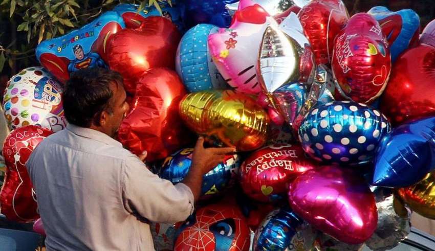 کراچی، ایک محنت کش کھلونے نما غبارے فروخت کرنے کیلئے سجا ..