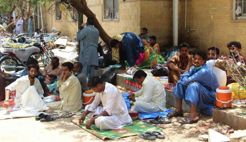 کراچی، سول ہسپتال کے باہر مریضوں کے تیماردار سخت گرمی میں ..