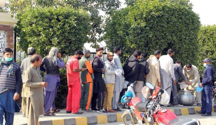 لاہور، شہری مستحق افراد میں کھانا تقسیم کر رہا ہے۔