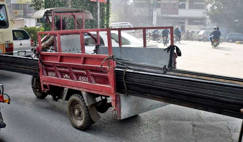لاہور، ایک شخص چنگ چی رکشے پر بغیر حفاظتی انتظامات لوہے ..