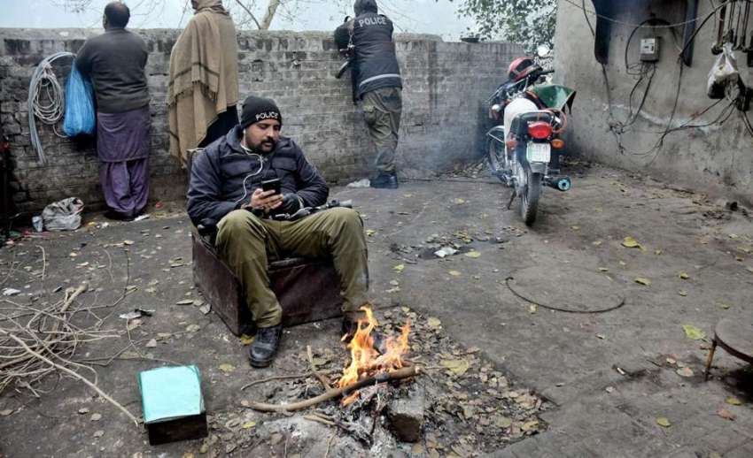 لاہور، ڈیوٹی پر تعینات پولیس اہلکار سردی کی شدت کم کرنے ..