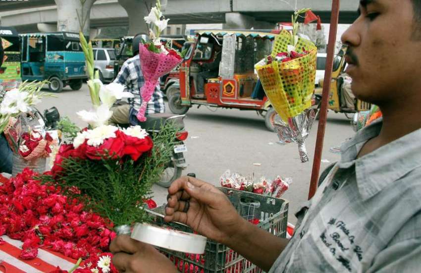 کراچی، ایک پھول فروش پھولوں کا گلدستہ بنا رہا ہے۔