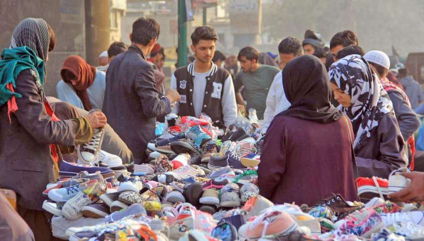 کراچی، تین ہٹی کے علاقہ میں شہری استعمال شدہ جوتے خرید رہے ..