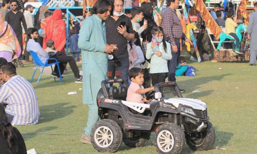 لاہور، جیلانی پارک میں جشن بہاراں میلے میں ایک بچہ کھلونا ..