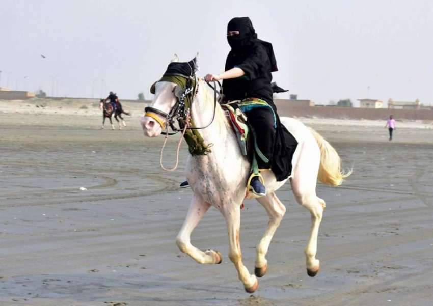 کراچی، ساحل سمندر پر ایک خاتون گھڑ سواری کر رہی ہے۔