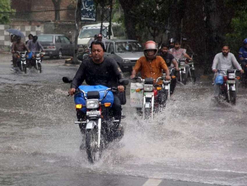 لاہور، شہری بارش کے دوران اپنی منزل کی جانب گامزن ہیں۔