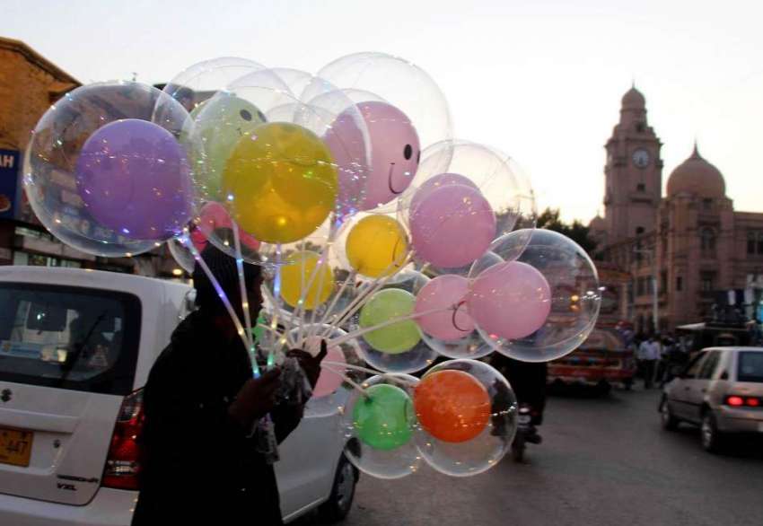 کراچی، ایک محنت کش لائٹ والے غبارے فروخت کر رہا ہے۔