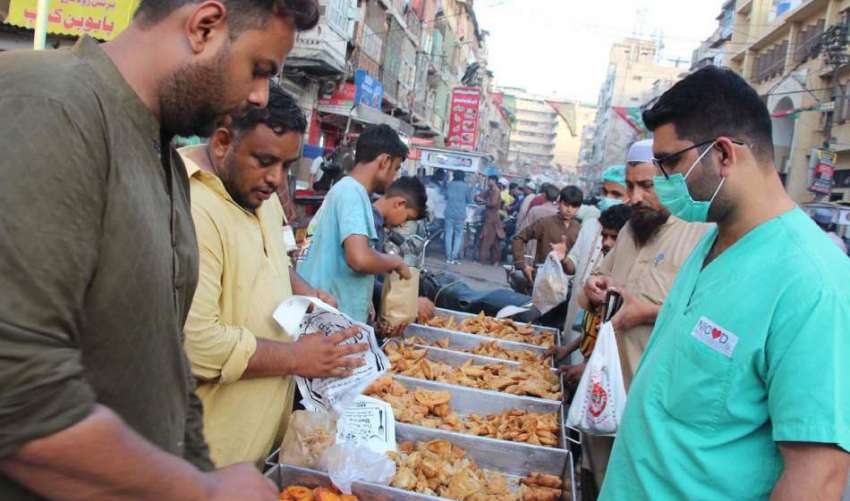 کراچی، شہری افطاری سے قبل مقامی دکان سے پکوڑے اور سموسے ..