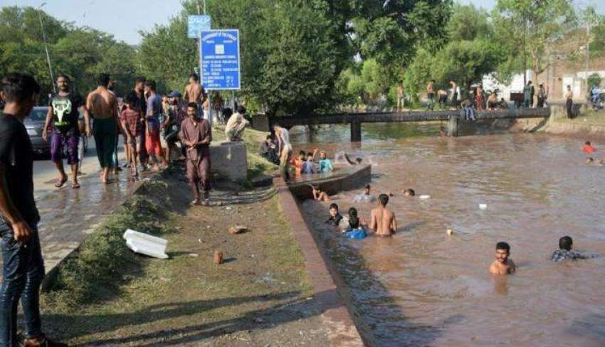 لاہور، شہری گرمی کی شدت کم کرنے کیلئے نہا رہے ہیں۔