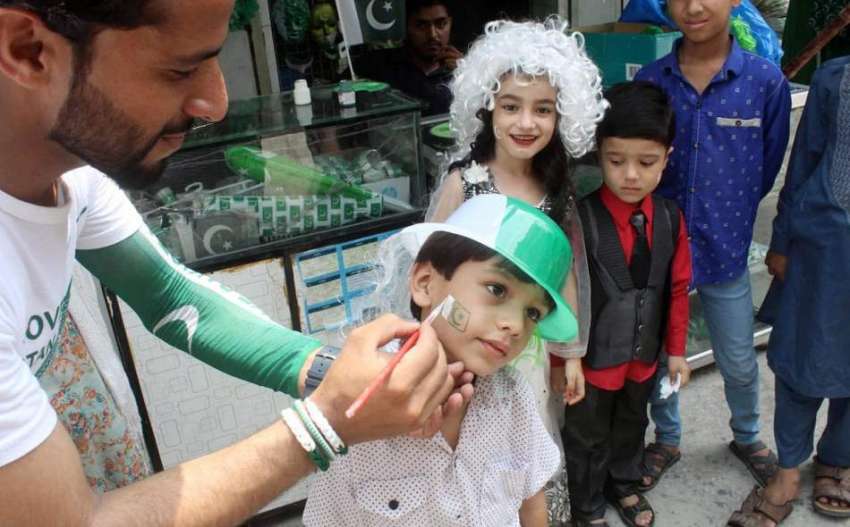 راولپنڈی، جشن آزادی کے موقع پر بچے اپنے چہرے پر جھنڈا بنوا ..