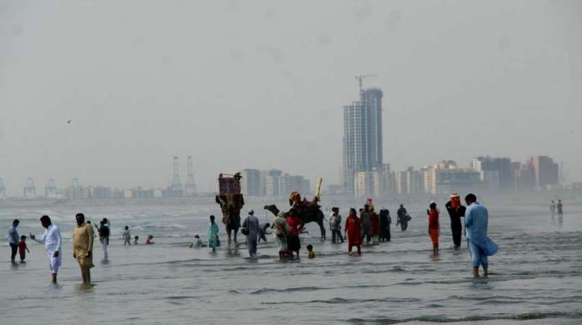کراچی، شہری مون سون بارش کے موسم میں سمندر کنارے سمندری ..