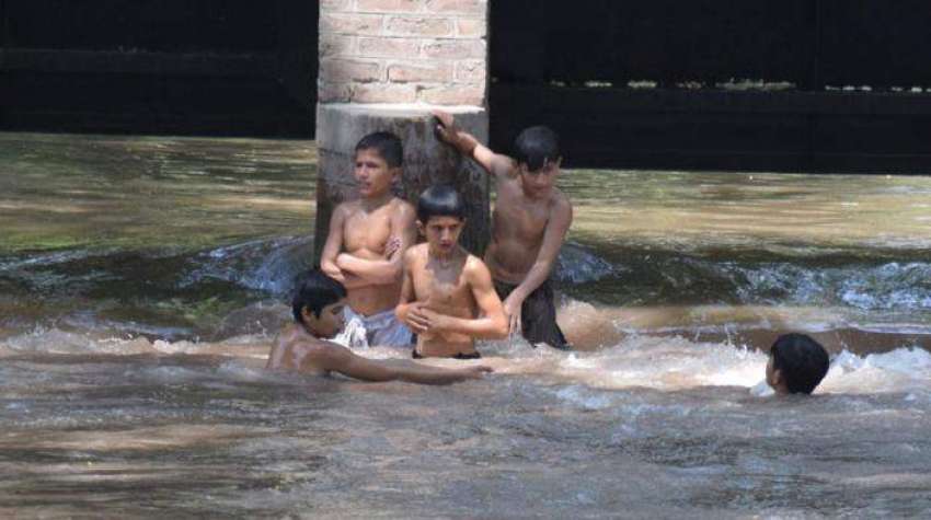 لاہور، بچے گرمی کی شدت کم کرنے کیلئے نہر میں نہا رہے ہیں۔