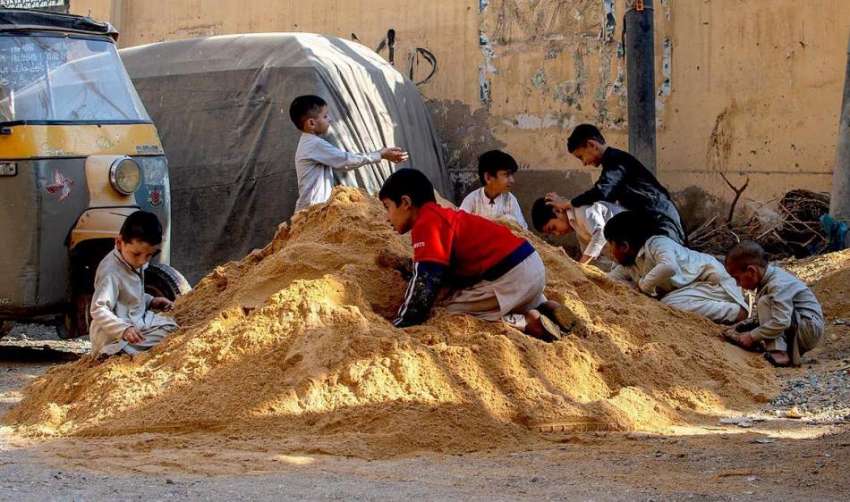 کراچی، بچے ریت کے ڈھیر پر کھیل کود میں مصروف ہیں۔