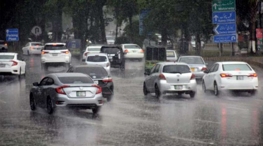 لاہور، گلبرگ کے علاقے میں بارش کے دوران ٹریفک رواں دواں ..