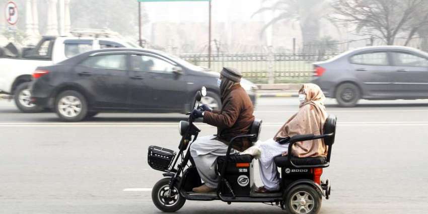 لاہور، ایک فیملی چھوٹی گاڑی پر سوار ہو کر مال روڈ سے گزر ..