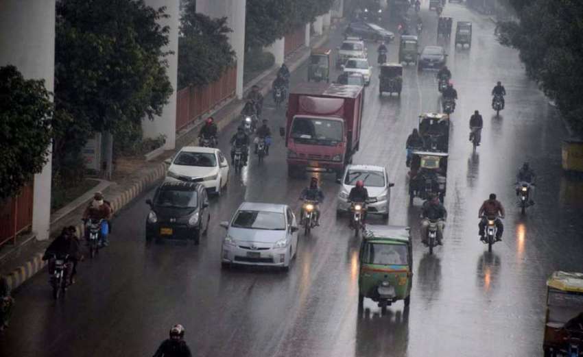 لاہور، صوبائی دارالحکومت میں بارش کے دوران شہری اپنی منزل ..