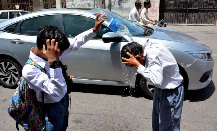 کراچی، شدید گرمی کی لہر میں سکول کے بچے سر پر پانی ڈال رہے ..