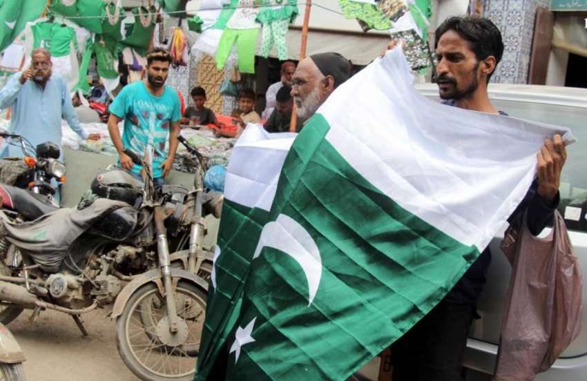 کراچی، پیپر مارکیٹ جشن آزادی کے موقع پر باپ بیٹا قومی پرچم ..