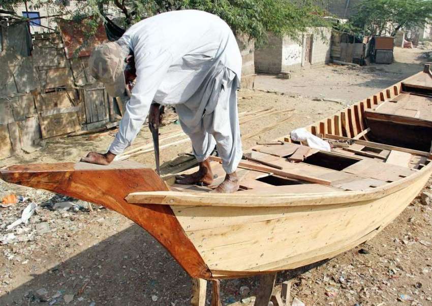 کراچی، ابراہیم حیدری میں ایک کاریگر کشتی بنانے میں مصروف ..