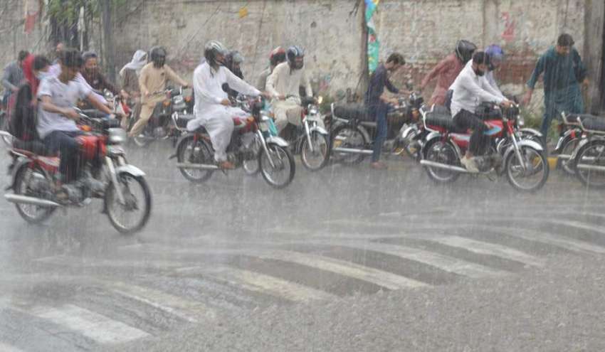 لاہور، صوبائی دارالحکومت میں ہونے والی بارش کے بعد شہری ..