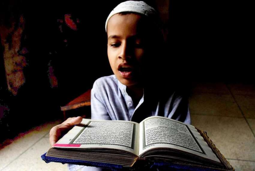 کراچی، رمضان کریم میں ایک بچہ مسجد میں قرآن شریف پڑھ رہا ..