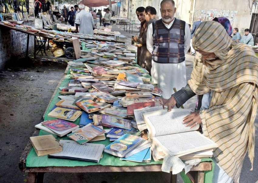 لاہور، نیلا گنبد کے باہر شہری پرانی کتابیں خرید رہے ہیں۔