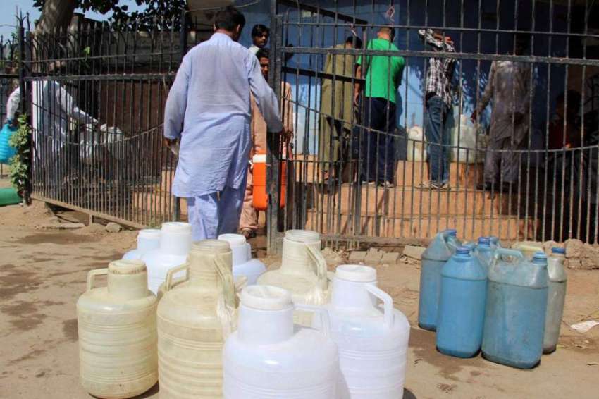کراچی، گذری کے علاقے میں پانی کی قلت کے باعث شہری ٹنکی سے ..