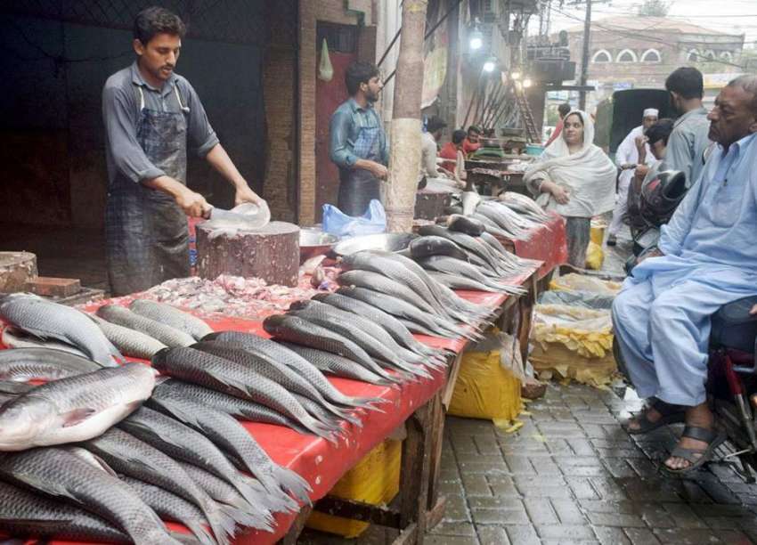 لاہور، ایک دکاندار مچھلی تیار کر رہا ہے۔ موسم سرما کی آمد ..