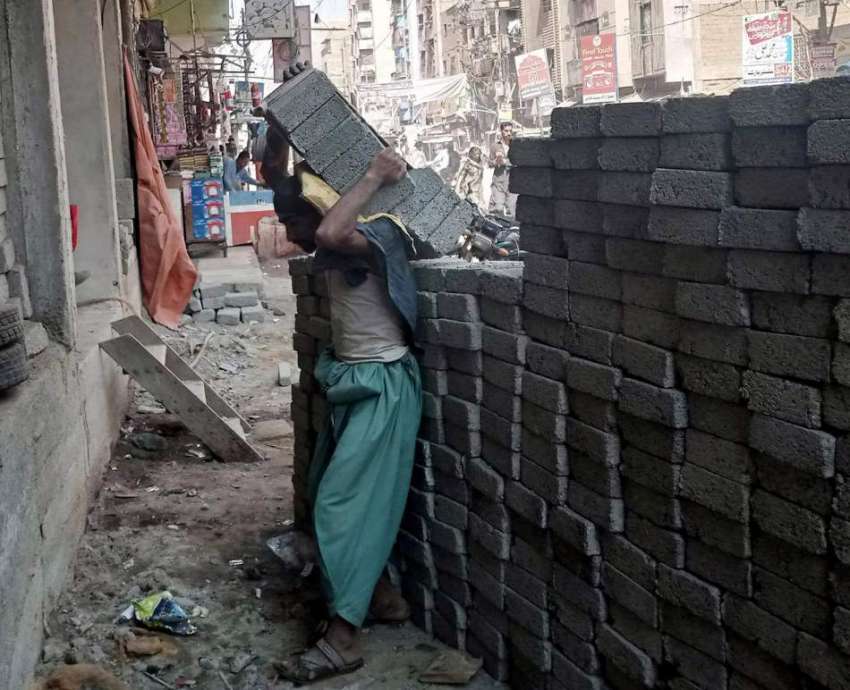 کراچی، مزدور سخت گرمی کے دوران کندھے پر بلاک اُٹھانے کے ..