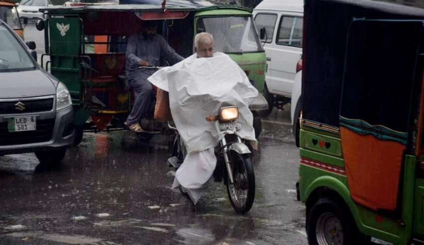 لاہور، موٹرسائیکل سوار شہری نے بارش سے بچنے کیلئے خود کو ..