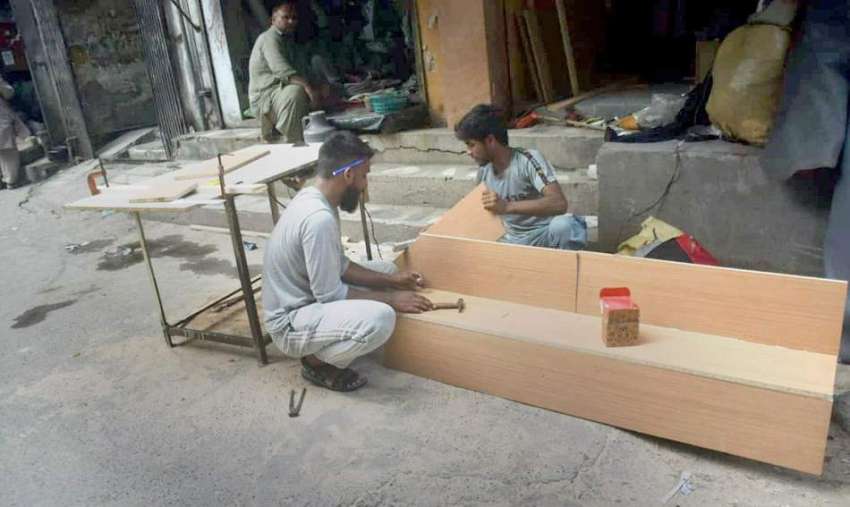 لاہور، کاریگر لکڑی کا بینچ تیار کر رہے ہیں۔