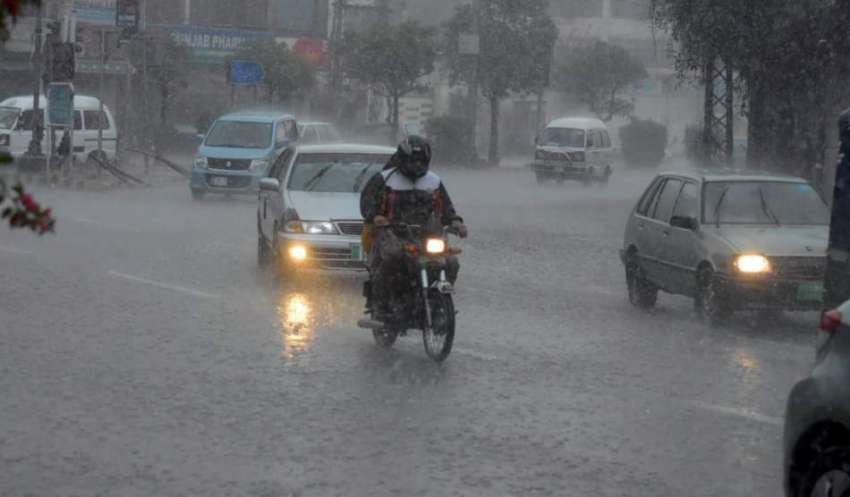 لاہور، شہری موسلادھار بارش میں اپنی منزل کی جانب گامزن ہیں۔