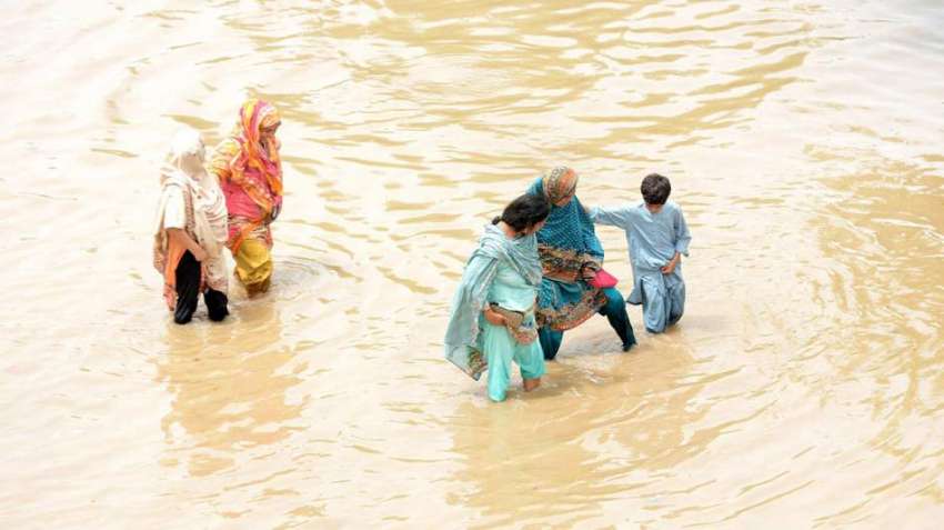 لاہور، والٹن کے علاقہ میں خواتین بارش کے پانی سے گزر رہی ..