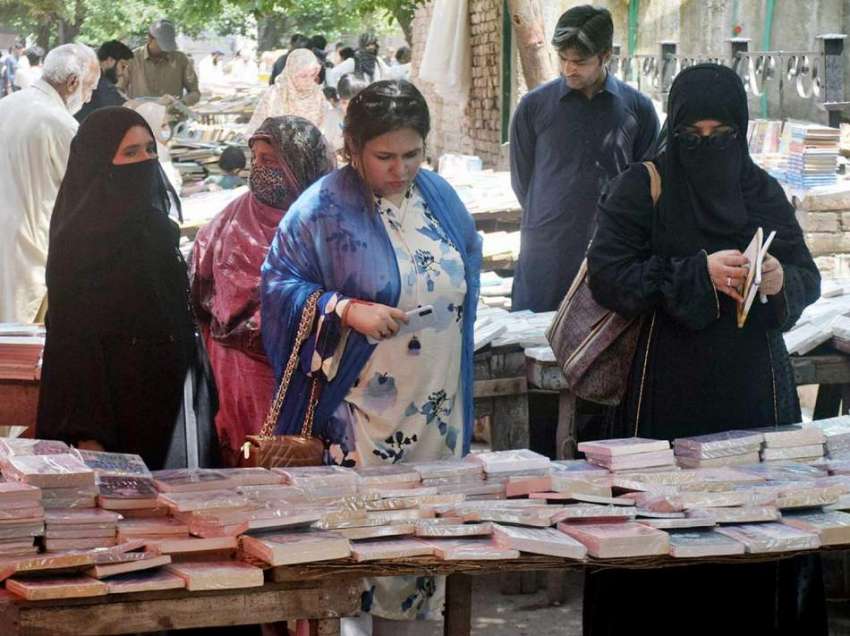 لاہور، خواتین نیلا گنبد چوک میں سٹال پر کتابیں دیکھ رہی ..