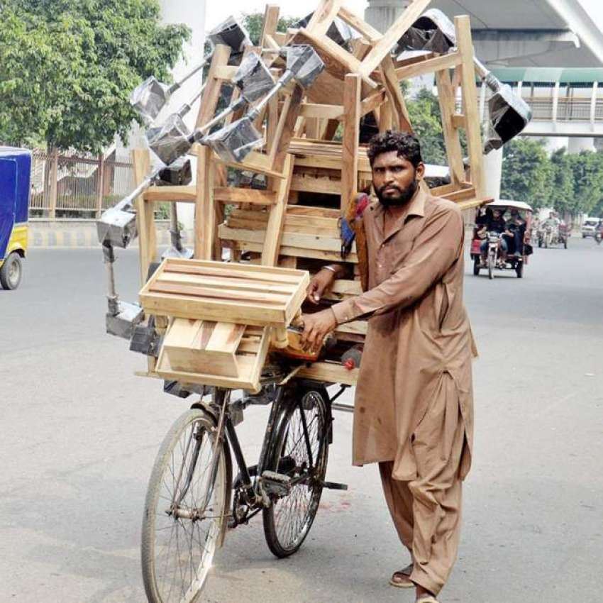 لاہور، محنت کش سائیکل پر فریج کی چوکیاں اور سٹول فروخت کر ..