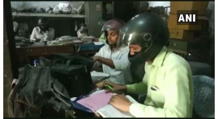 بھارتی دفتر میں ملازمین نے چھت گرنے کے ڈر سے سر کی چوٹ سے بچنے کے لیے ہیلمٹ پہننا شروع کر دئیے