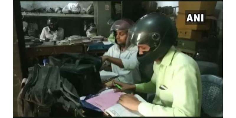 بھارتی دفتر میں ملازمین نے چھت گرنے کے ڈر سے سر کی چوٹ سے بچنے کے لیے ..